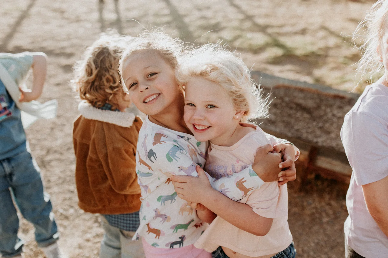 Family enjoying picnic on grass surrounded by farm animals